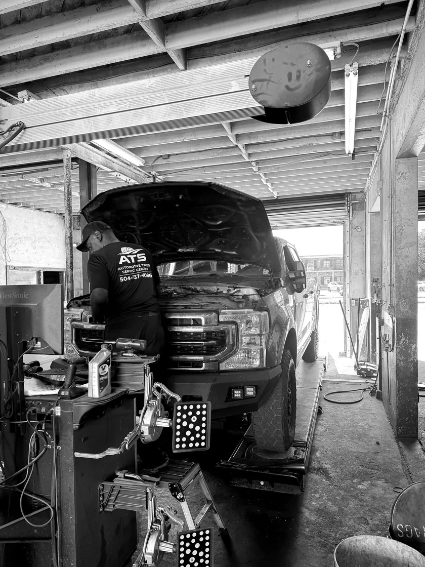 ATS Auto Repair technician working under the hood of a Ford truck